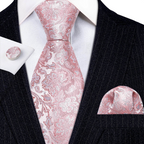 Pink paisley tie set with matching pocket square and cufflinks on a black suit.