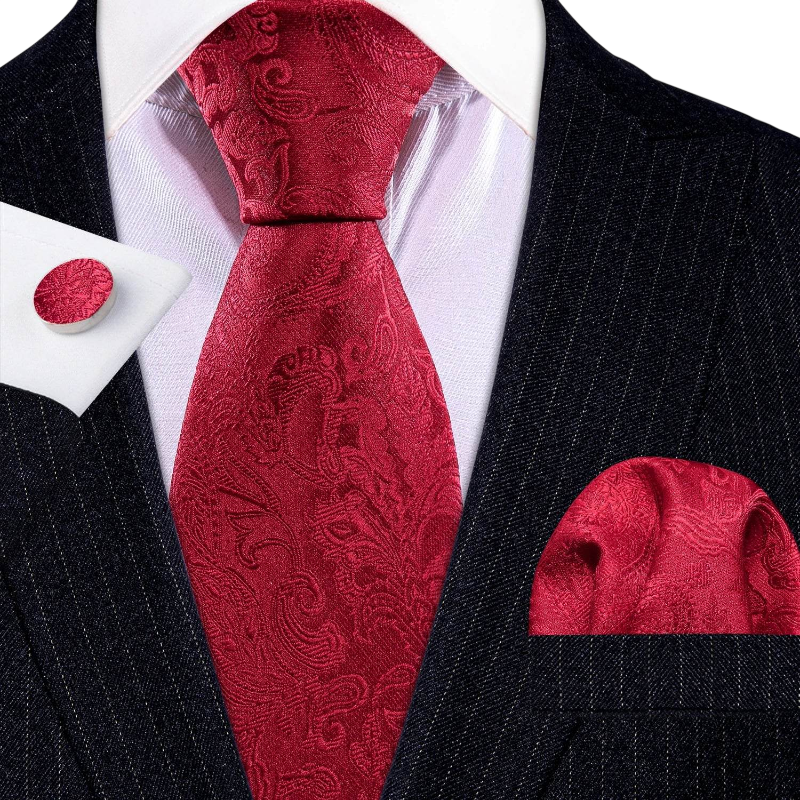 Red paisley tie set with matching pocket square and cufflinks on a black suit.