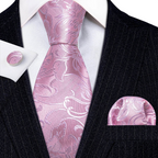 Pink paisley tie set with matching pocket square and cufflinks on a black suit.