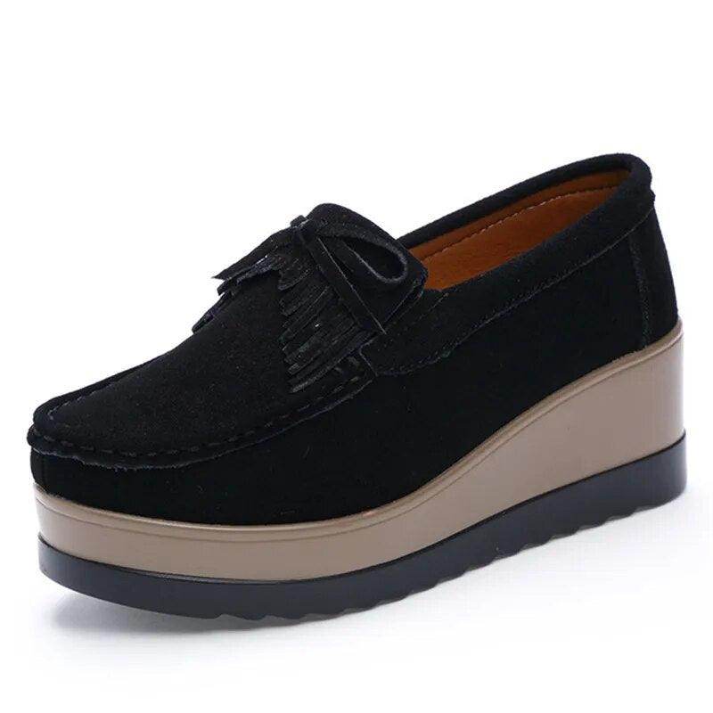 Black VacationGrabs platform slip-ons for travel featuring a stylish fringe detail and cushioned sole.