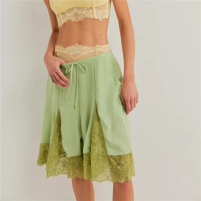 Women's green satin shorts with lace trim, perfect for lounging