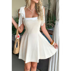 Women's square neck dress in cream with bow straps, perfect for summer outings